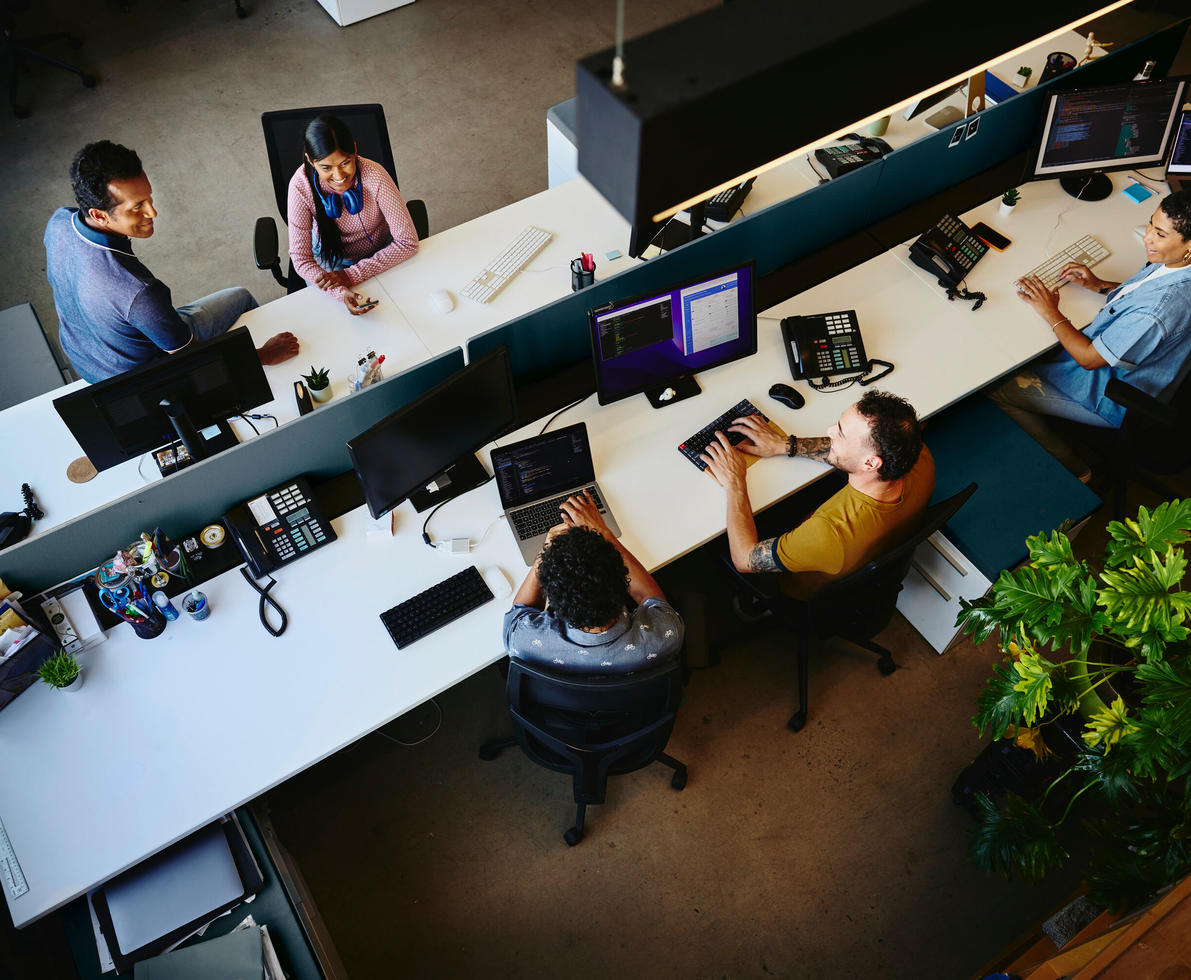 Bird view of people working at an office setting, sitting behind a computer